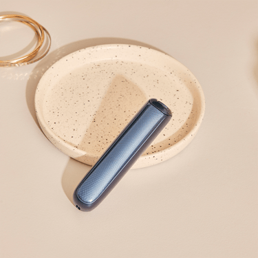 Ploom AURA front panels with Navy Blue Augmented Pattern placed on a table
