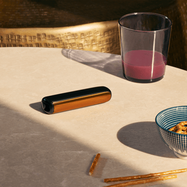 Ploom AURA front panel Mango Sorbet accessory attached to device on a table