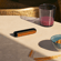 Ploom AURA front panel Mango Sorbet accessory attached to device on a table