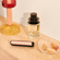 Ploom AURA front panels with Rose Gold Augmented Pattern placed on a dressing table
