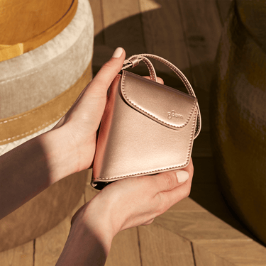 Ruka koja drži Ploom AURA Rose Gold Duo futrolu