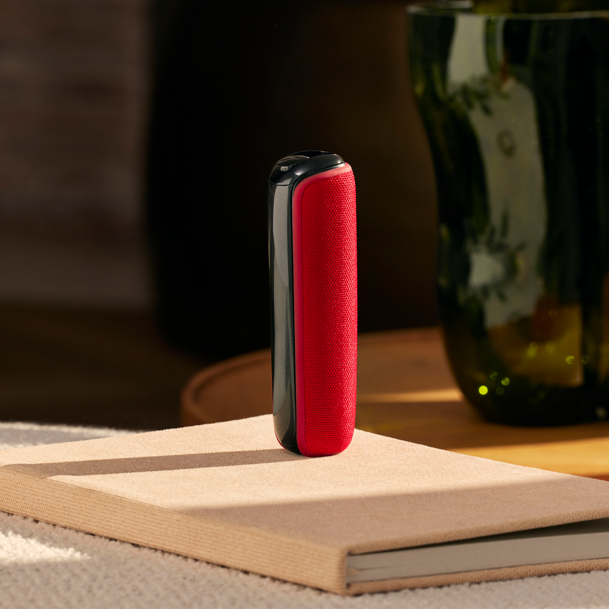 Ploom device with Lava Red Back Cover on book
